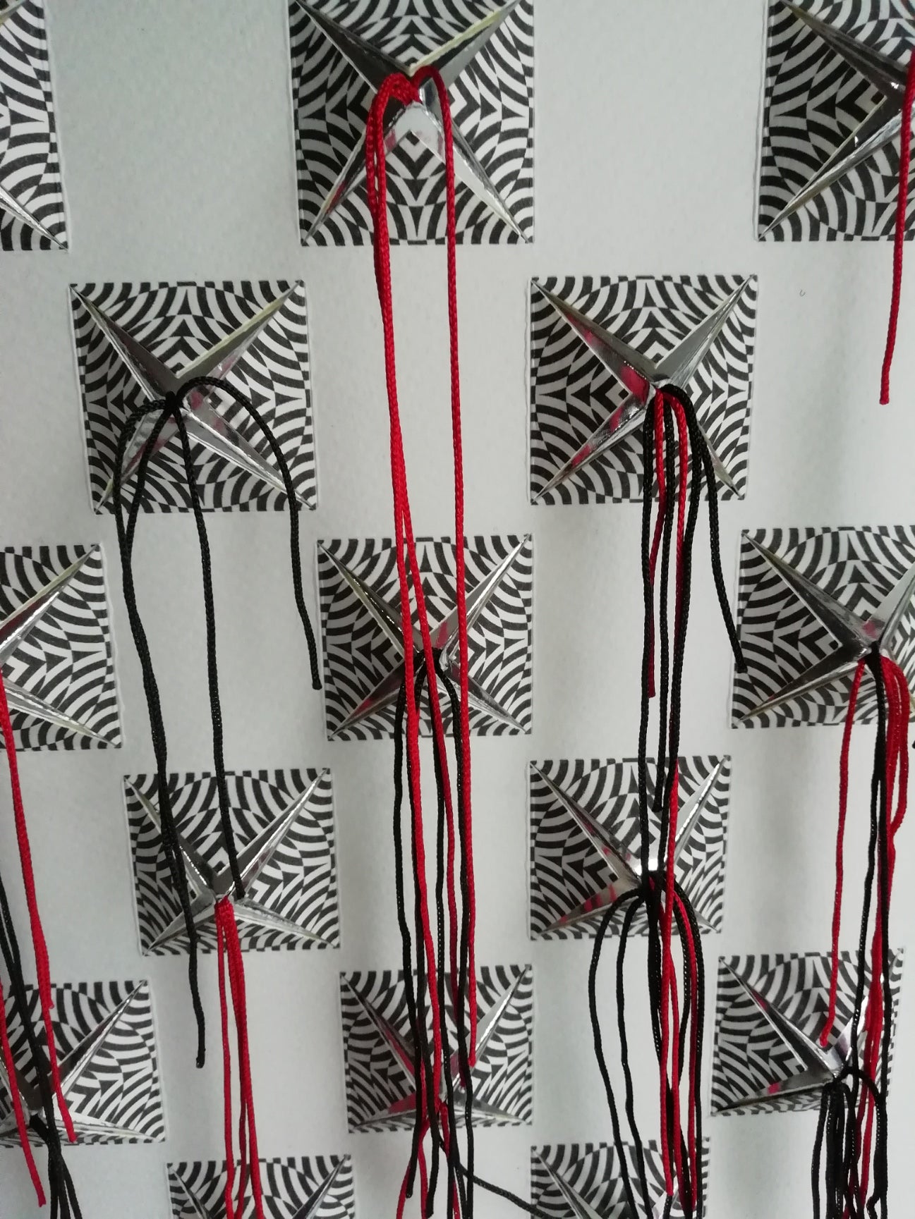 Pop éclosion, paper art 3D, vue de près, carrés psychédéliques éclatés et fils noirs/rouges